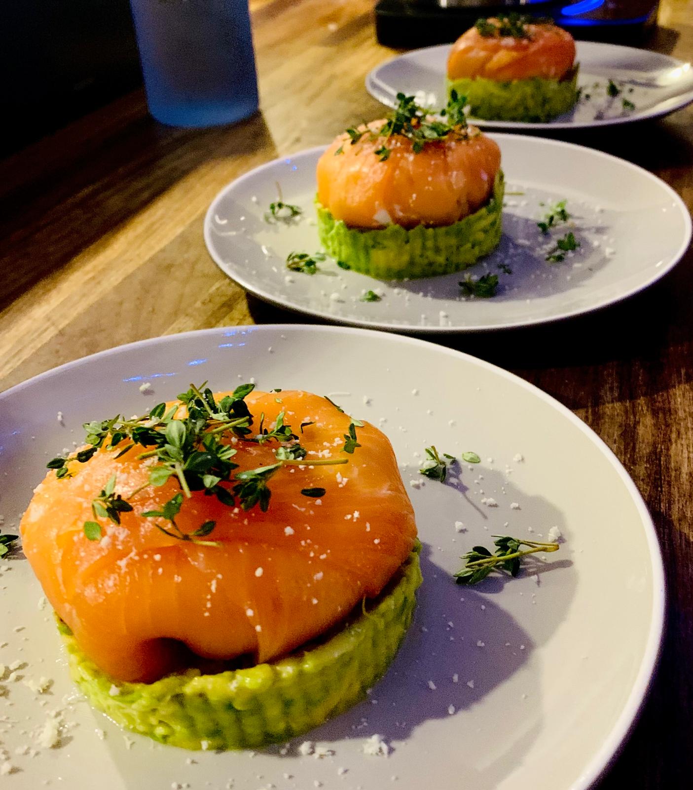 Stuffed smoked salmon with cream cheese on fresh avocado base